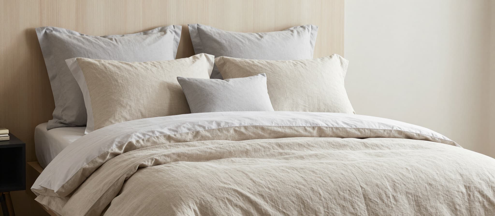 Layered bed with linen duvet cover and shams in natural tones
